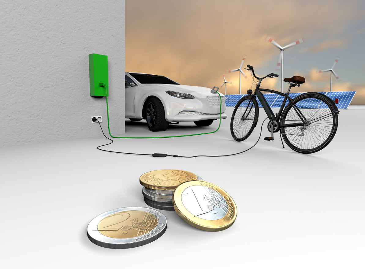An electric bicycle and an electric car charge their batteries. Euro coins are in the foreground. Solar panels and wind turbines are in the background. Brandless car an bicycle. No real prototypes.